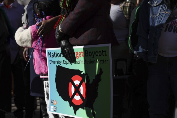 A community member holds a sign calling for a national boycott of Target stores during a news conference outside Target Corporation's headquarters in Minneapolis, Minn., Jan. 30, 2025. (AP Photo/Ellen Schmidt, File)